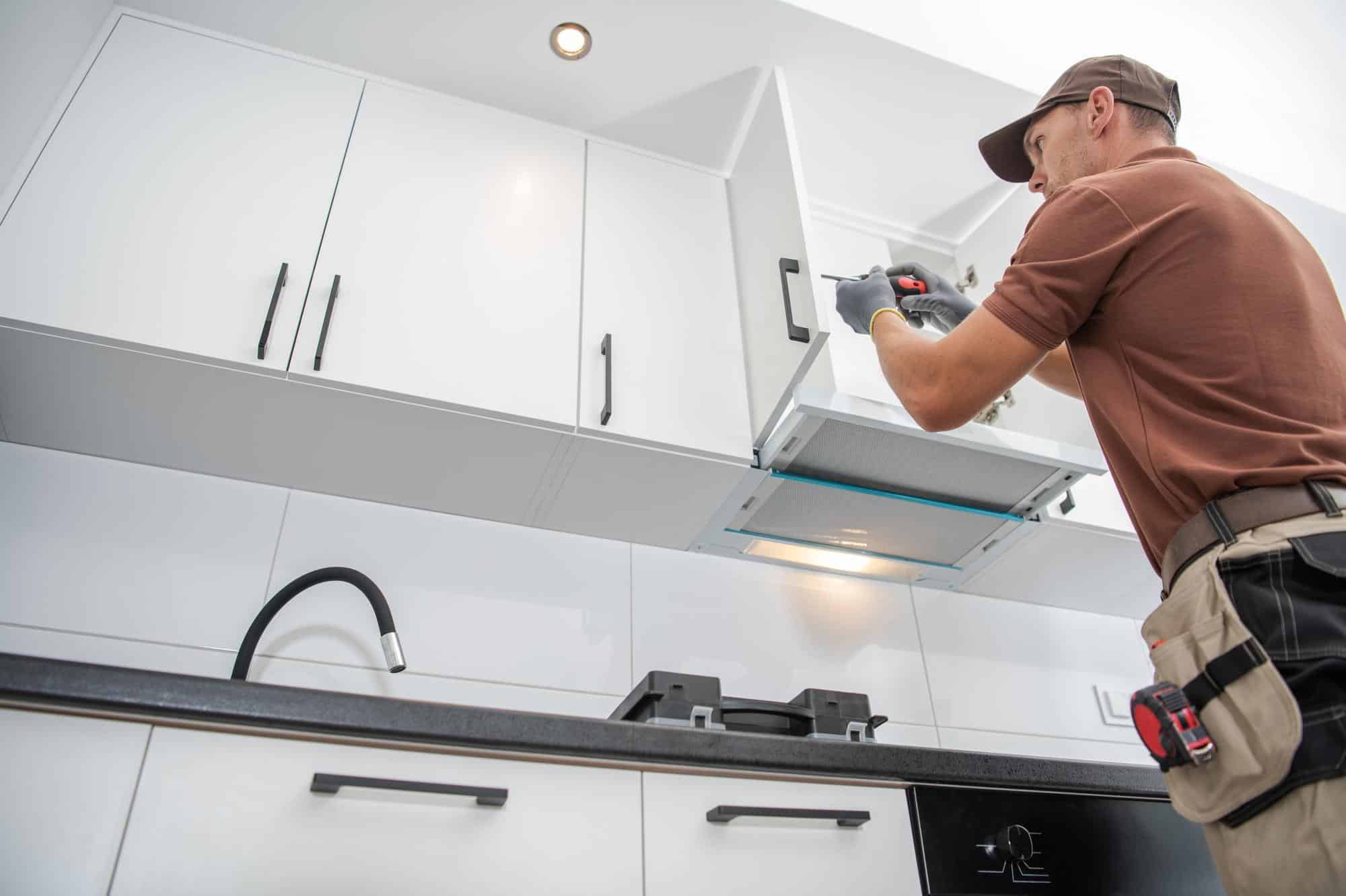 Contractor installing kitchen cabinets during a kitchen remodeling in Huntington Beach, showcasing precise craftsmanship and modern design.