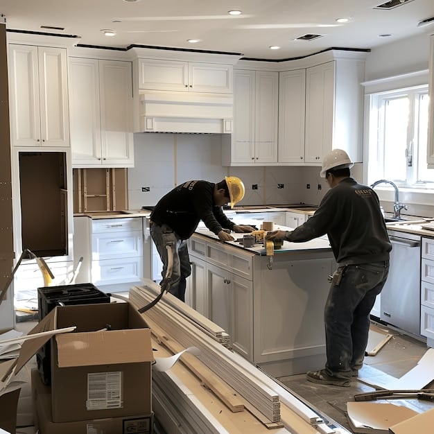 Construction workers installing new cabinets during a kitchen remodeling project in Orange County.